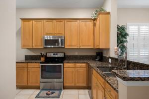 a kitchen with wooden cabinets and stainless steel appliances at 1061 Cinnamon Beach, 3 Bedroom, Sleeps 8, 2 Pools, Elevator, Pet Friendly in Palm Coast