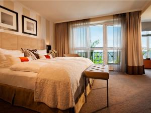 ein Schlafzimmer mit einem großen Bett und einem großen Fenster in der Unterkunft Strandhotel Ostseeblick in Heringsdorf