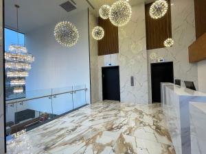 a lobby with a marble floor and chandeliers at Liberty View Brooklyn Hotel in Brooklyn