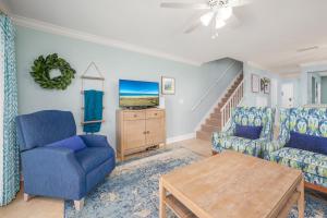 een woonkamer met blauwe stoelen en een tafel bij Sea Place 11205, 2 Bedrooms, Beach Front, Pool, Tennis, WiFi, Sleeps 6 in St. Augustine