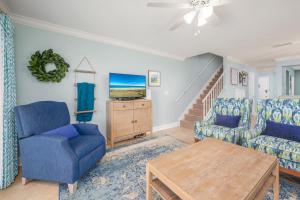 a living room with blue chairs and a table at Sea Place 11205 in Saint Augustine