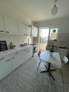 a kitchen with white cabinets and a table with a potted plant at Appartement dans un beau quartier à Anderlecht in Brussels