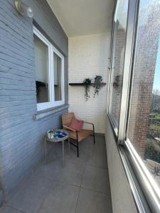 d'une terrasse avec une chaise, une table et une fenêtre. dans l'établissement Appartement dans un beau quartier à Anderlecht, à Bruxelles