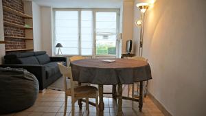 uma sala de estar com uma mesa com cadeiras e um sofá em Little Suite - Coline em Lille