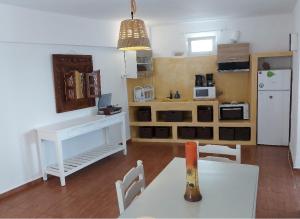 a living room with a white table and a kitchen at Villa Adriana in Parikia