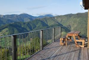 a wooden deck with a bench and a view of mountains at Kea Ridge King Ensuite Room in Riwaka