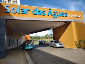 a sign for a solar gas station with cars parked under it at Solar das Águas Park Resort - Apartamento em Olímpia para 5 pessoas in Olímpia