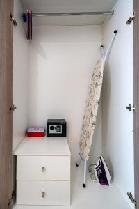 a room with a closet with a clock on a dresser at White & Gray apartment in Rethymno