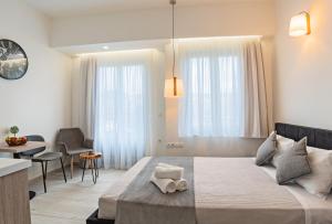 1 dormitorio con 1 cama grande, mesa y sillas en White & Gray apartment, en Rethymno