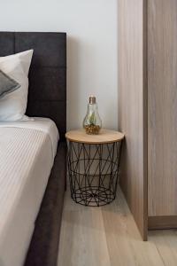 a side table with a vase on it next to a bed at White & Gray apartment in Rethymno