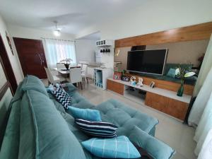 a living room with a blue couch and a television at Casa de praia no Peró Cabo Frio com Piscina e Hidromassagem in Cabo Frio