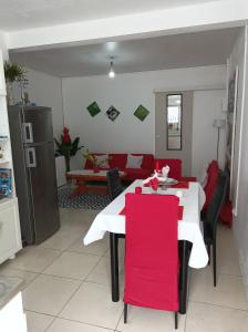 a living room with a white table and red chairs at VILLA AU COEUR DE LA MARMITE in Sainte-Marie