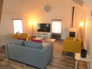 sala de estar con sofá, sillas y TV en Maison de ville, fibre et Netflix, en Belfort