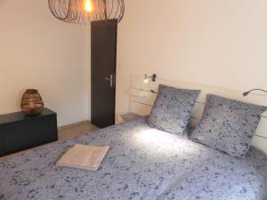Un dormitorio con una cama azul con dos almohadas. en LE STRASBOURG - Confortable maison de ville, en Belfort