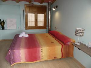 a large bed in a room with a table at Cal Pedrellar in Colldejou