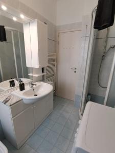 a white bathroom with a sink and a shower at Sweet Home in Trieste