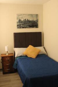 um quarto com uma cama com um edredão azul em Cómodo departamento céntrico y cerca a lugares turísticos de la ciudad em Arequipa