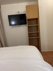 a bedroom with a bed and a tv on the wall at Hôtel Le Green in Le Havre