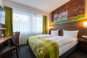 ein Hotelzimmer mit einem Bett und einem Schreibtisch in der Unterkunft Trip Inn Hotel Münster City in Münster
