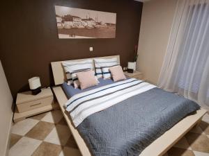a bedroom with a large bed with blue sheets and pillows at M&M Apartments in Biograd na Moru