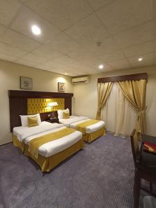 a hotel room with two beds and a window at Saryet Al Hamra Hotel Apartments in Jeddah
