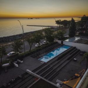 una vista aérea de una piscina en un aparcamiento junto al agua en Dos Orillas - Apartamento 510, en Colonia del Sacramento