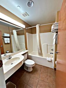 a bathroom with a toilet and a sink and a tub at WELCOME INN & SUITES in Tunica Resorts