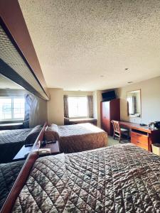 a hotel room with two beds and a desk at WELCOME INN & SUITES in Tunica Resorts