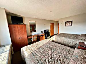 a hotel room with two beds and a desk at WELCOME INN & SUITES in Tunica Resorts