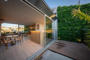 a glass extension of a house with a garden at We Hate F Tourists in Lisbon