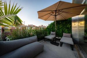 a patio with a couch and an umbrella and chairs at We Hate F Tourists in Lisbon