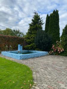 una fuente azul en medio de un jardín en Žubītes 8, en Jūrmala