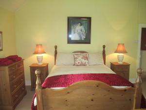 a bedroom with a wooden bed with two lamps at Tralia Farmhouse Self Catering in Farranfore