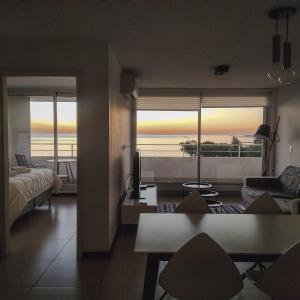 - un salon avec un lit et une vue sur l'océan dans l'établissement Dos Orillas - Apartamento 510, à Colonia del Sacramento
