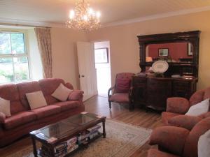 a living room with a couch and chairs and a mirror at Tralia Farmhouse Self Catering in Farranfore