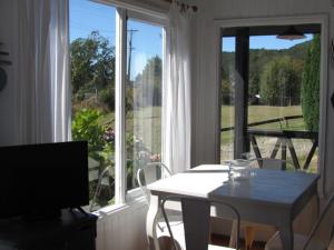 - un salon avec une table et une grande fenêtre dans l'établissement Cabaña Lourdes, à Puerto Corral