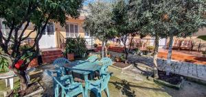 einen blauen Tisch und Stühle in einem Garten mit Bäumen in der Unterkunft Berti Apartment in Vlorë