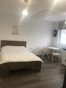 a bedroom with a bed and a table and a window at Garsoniera La Munte in Azuga