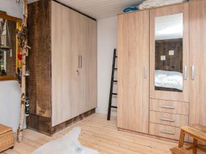 a room with wooden cabinets and a ladder in it at Holiday home Rømø CXXII in Bolilmark