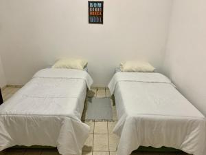 two beds sitting next to each other in a room at Hotel Colonial Suites ,Bracel, Lwart, Zilor in Lençóis Paulista