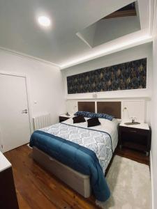 een slaapkamer met een groot bed en een blauw dekbed bij Private Room in Trafaria