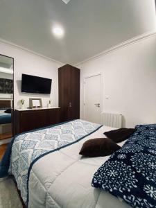 een slaapkamer met een bed en een tv aan de muur bij Private Room in Trafaria