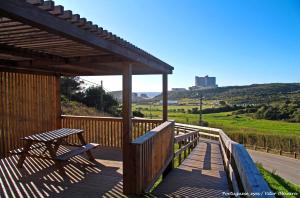 a wooden deck with a picnic table and a bench at By Santa in Santa Cruz