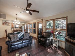 un soggiorno con mobili in pelle e ventilatore a soffitto di Midtown Riverfront 1 a Ruidoso