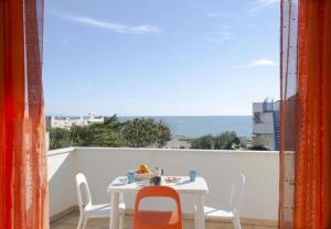 - Balcón con mesa blanca y sillas en ONDA BLU-Appartamenti, en Torre dell'Orso