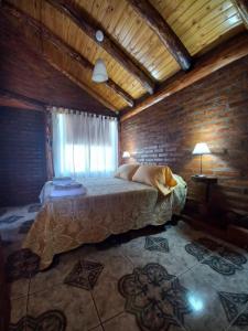 1 dormitorio con 1 cama en una habitación de madera en Cabañas Atrapasueños en Trevelín
