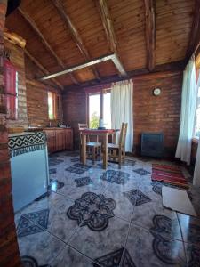 cocina con mesa y sillas en una habitación en Cabañas Atrapasueños en Trevelín