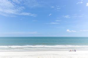 un grupo de personas de pie en una playa cerca del océano en Dreamview, en St. Augustine