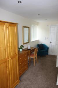 um quarto com uma secretária, uma mesa e uma cadeira em Broadwell Guest House em Meriden