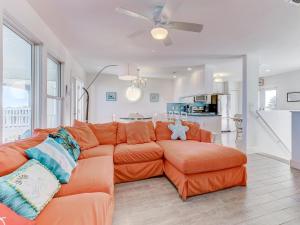 un salon avec un canapé orange et une cuisine dans l'établissement Four Palms, 4 Bedrooms, Sleeps 10, WiFi, Ocean Front, à Saint Augustine